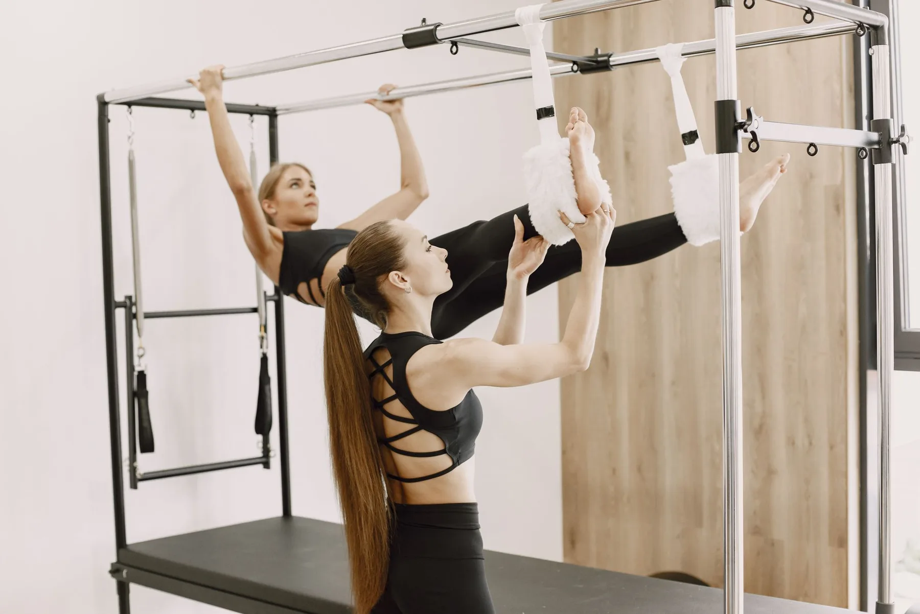 Deux pratiquantes s’étirent sur une tour de Pilates