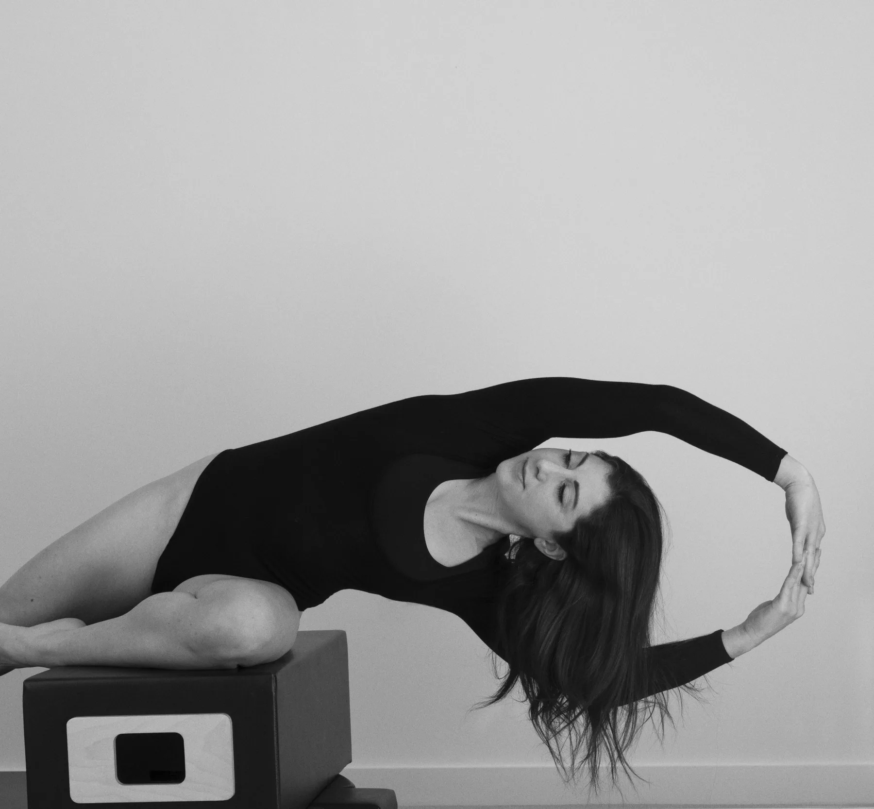 Étirement latéral sur une boîte de Pilates, en noir et blanc