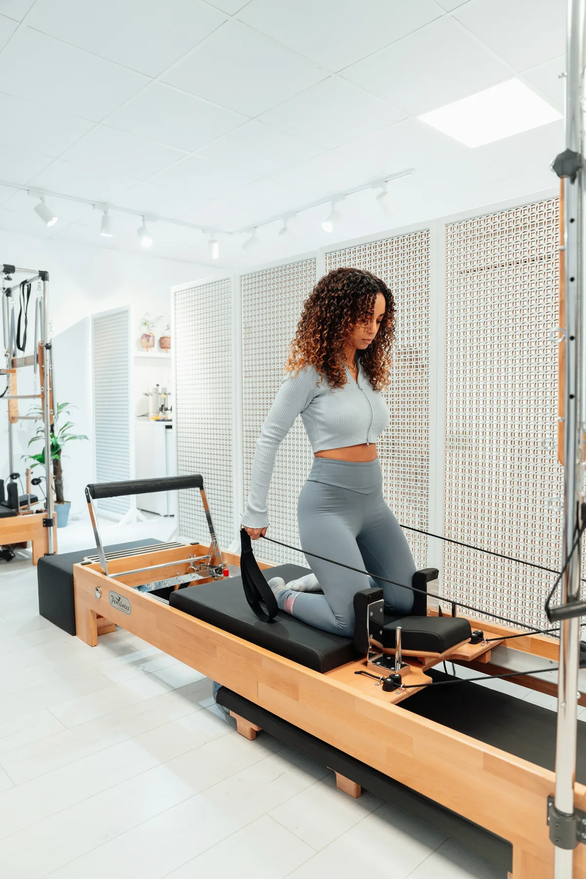 Pratiquante en fente, un pied sur le chariot du Reformer