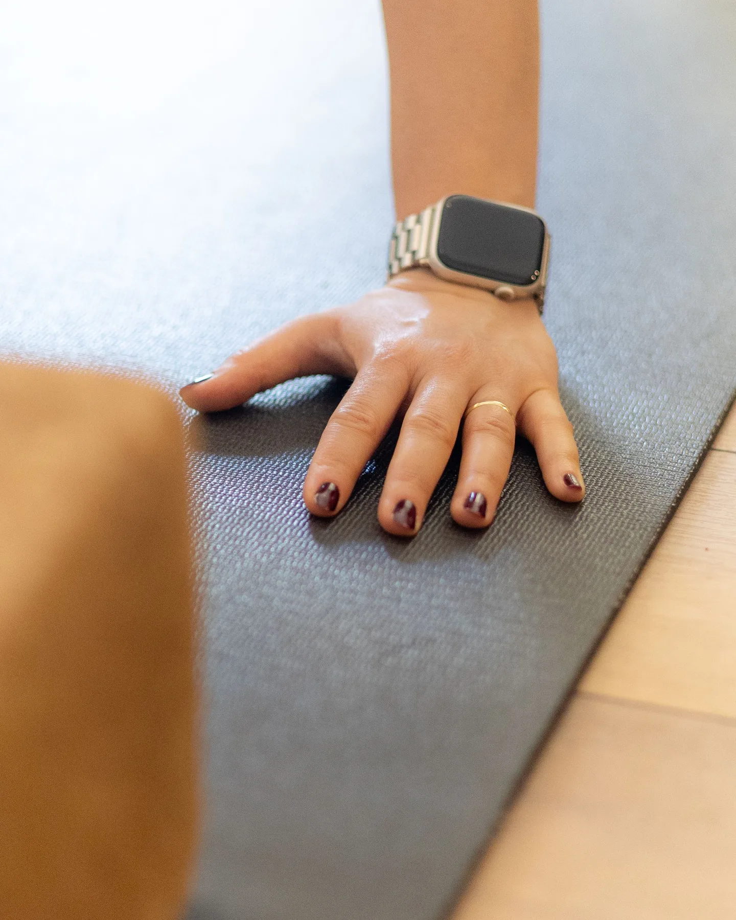 Main posée à plat sur un tapis, montre au poignet