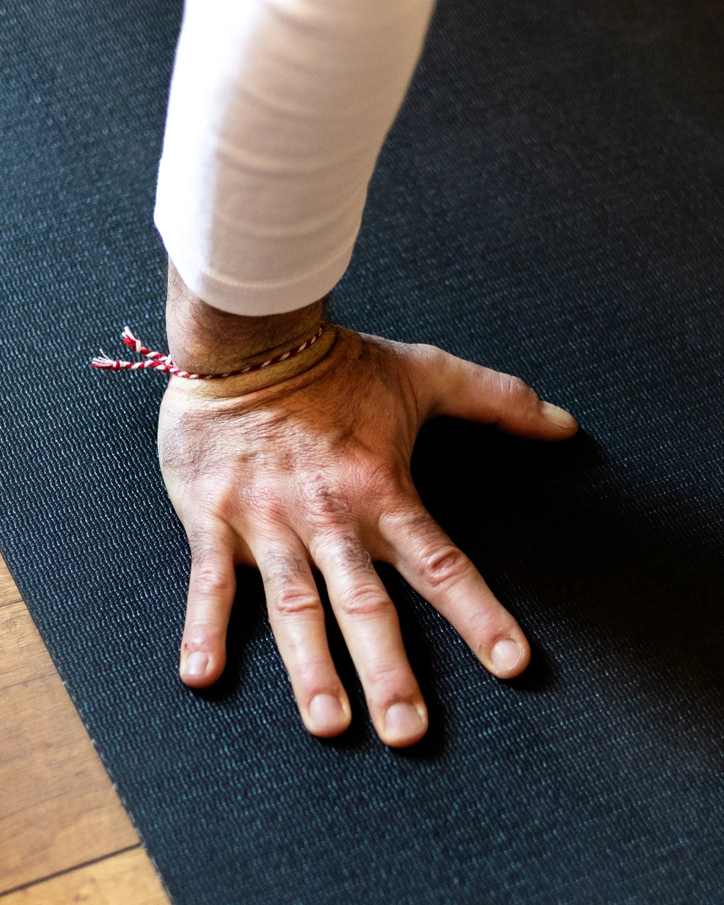 Main posée à plat sur un tapis sombre, doigts écartés