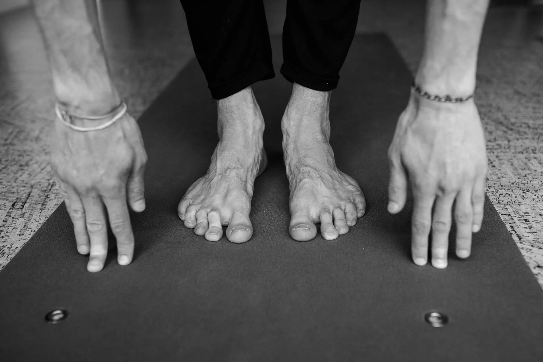 Mains et pieds posés sur un tapis, en noir et blanc