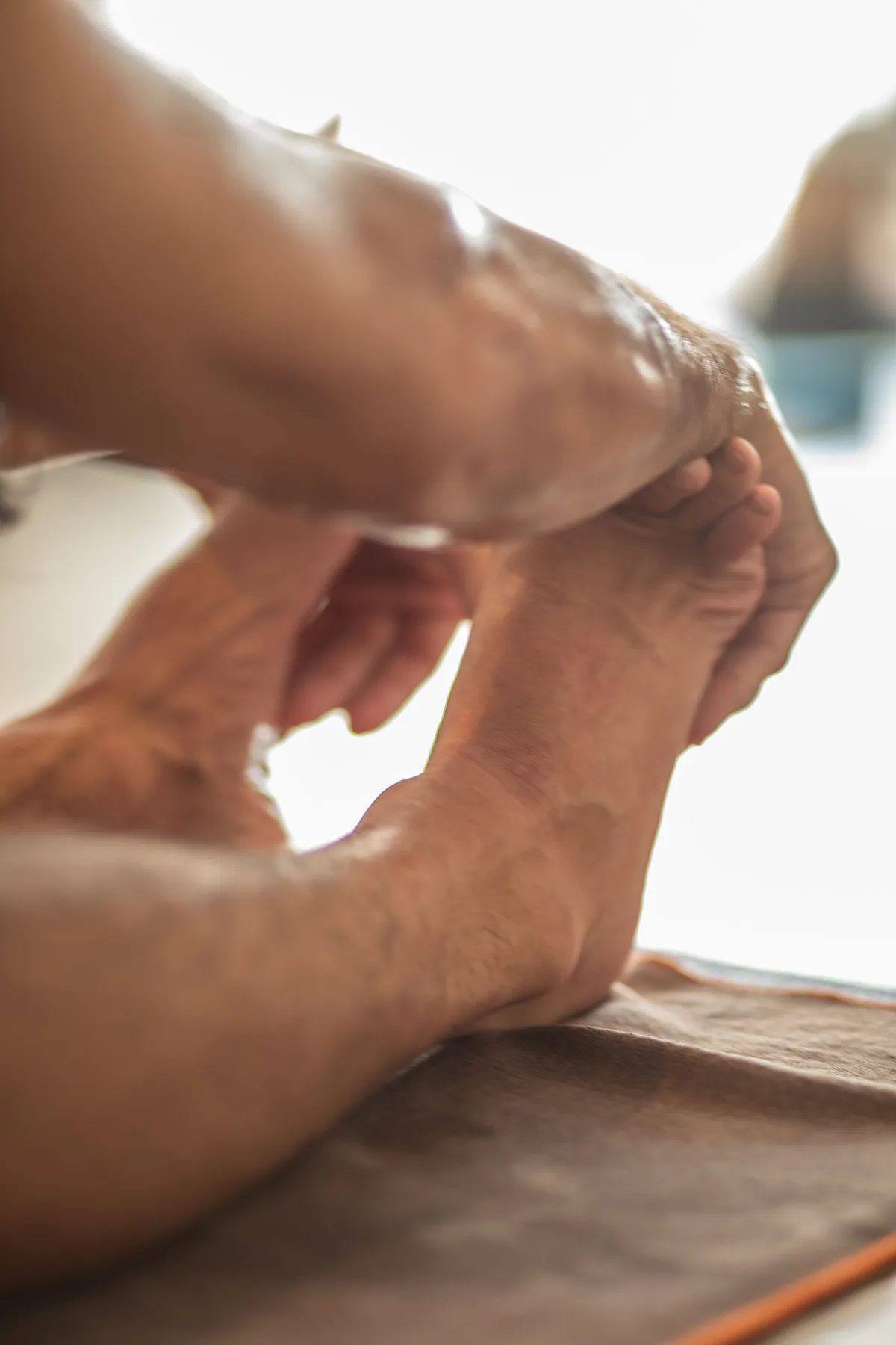 Mains qui saisissent les pieds pendant un étirement assis