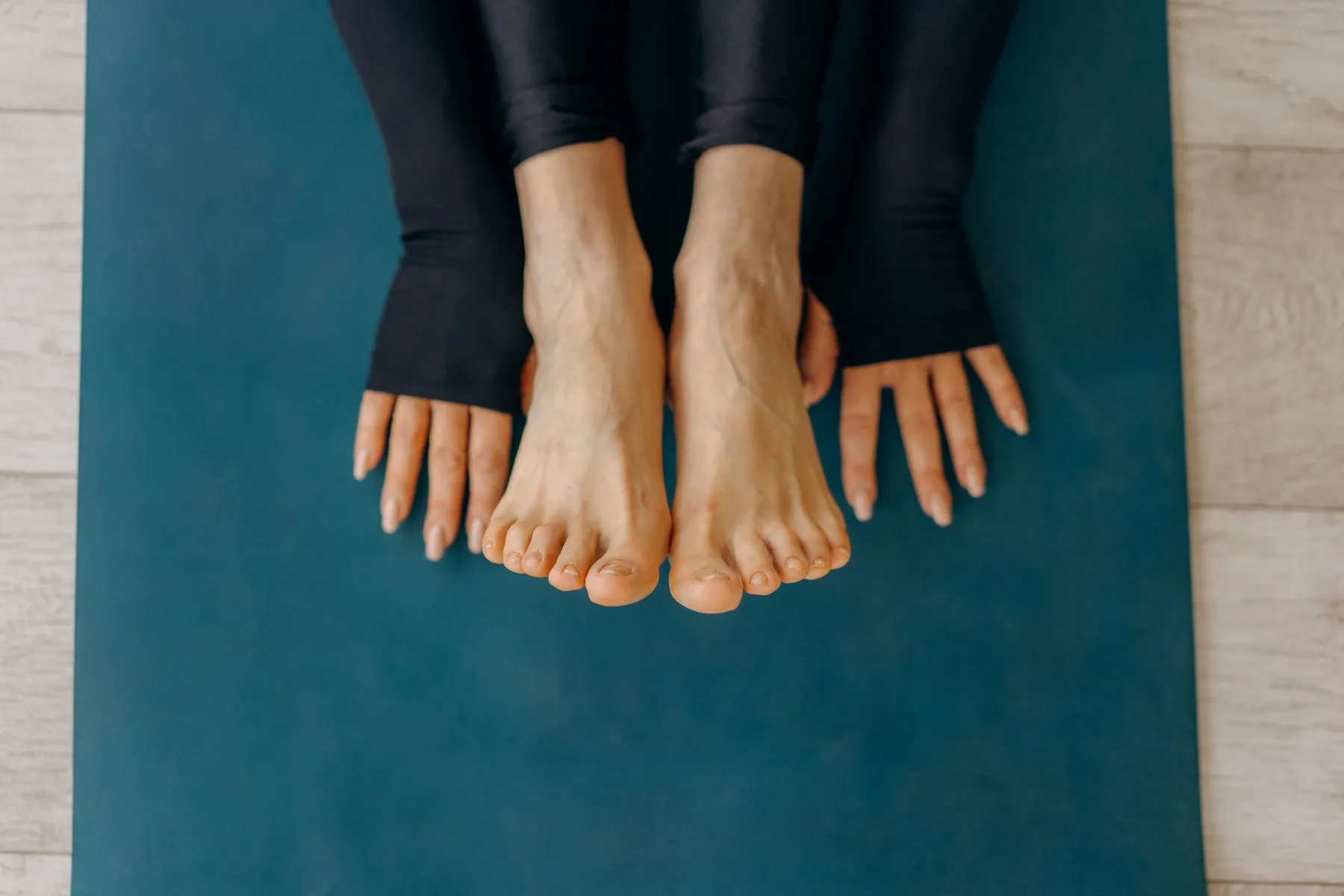 Pieds et mains posés sur un tapis bleu canard