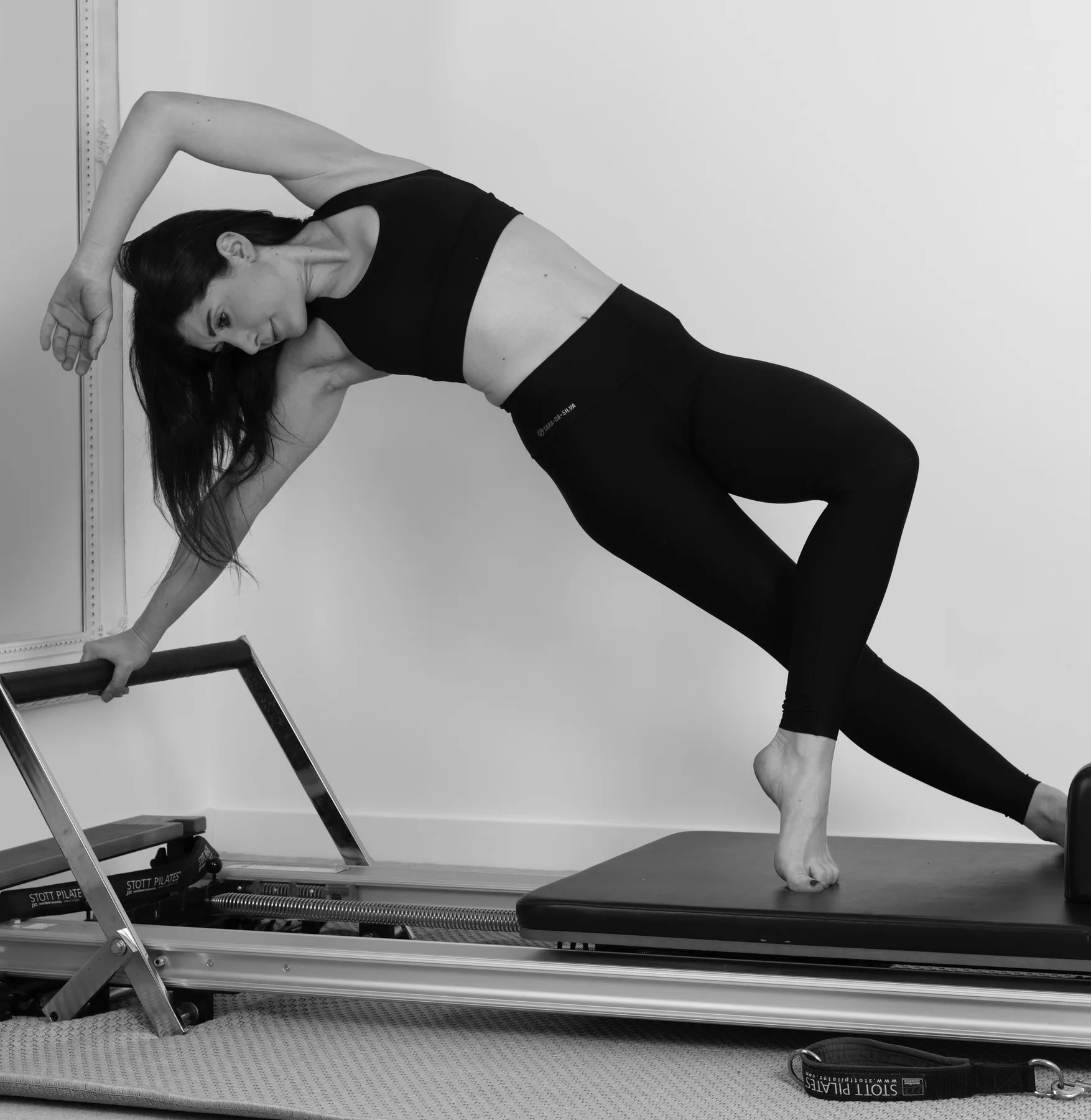 Planche latérale dynamique sur un Reformer, en noir et blanc
