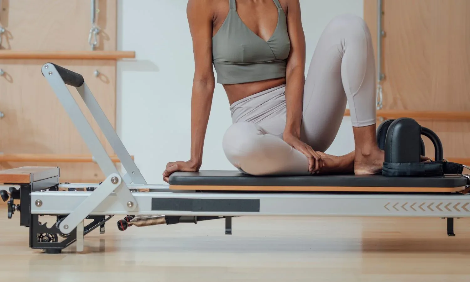 Image d’illustration : pratiquante assise sur le chariot d’un Reformer