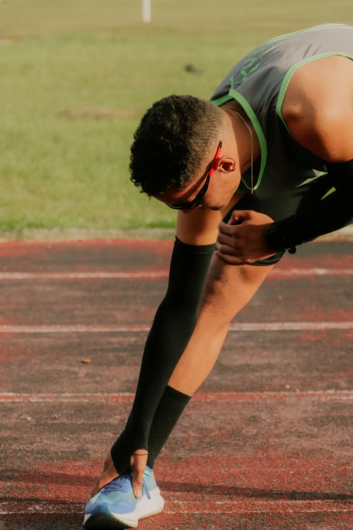 Sportif qui s’étire sur une piste d’athlétisme