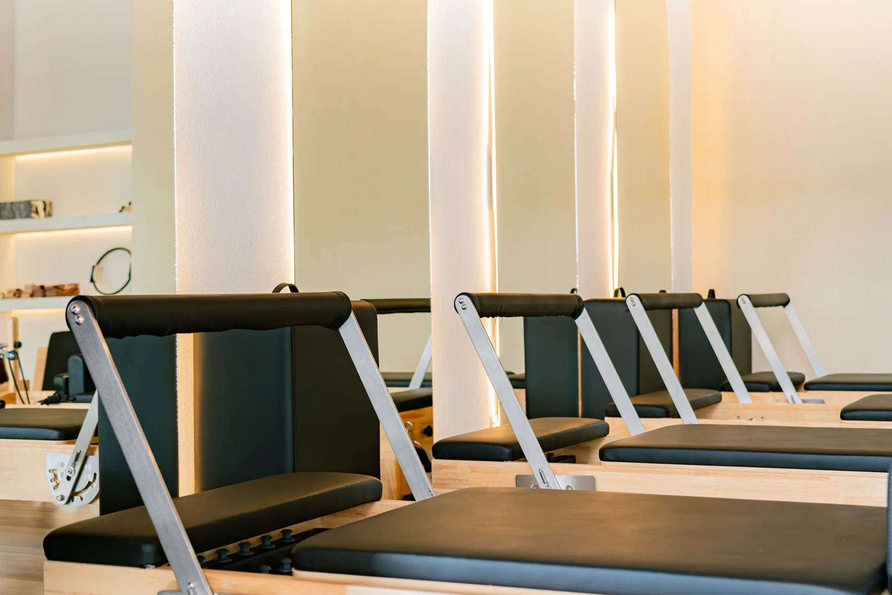 Studio de Pilates équipé de Reformers, lumière naturelle et murs clairs